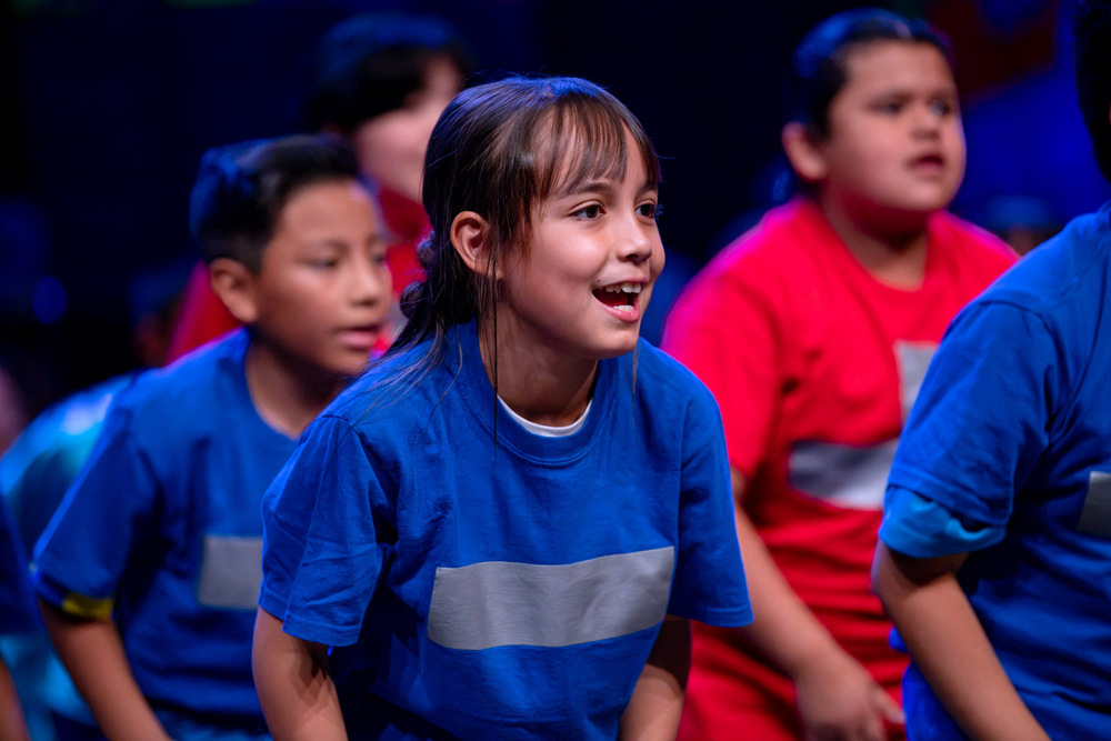 Student smiles as she performs choreography through the National Dance Institute of New Mexico Residency