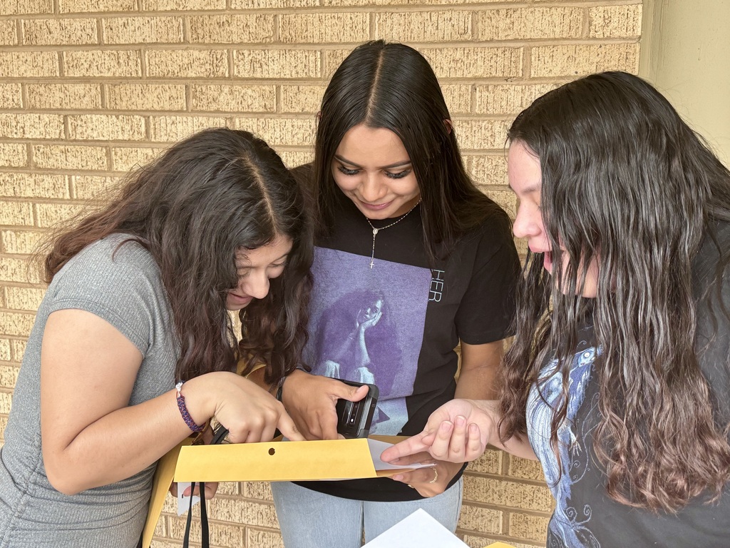 three girls looking at schedules