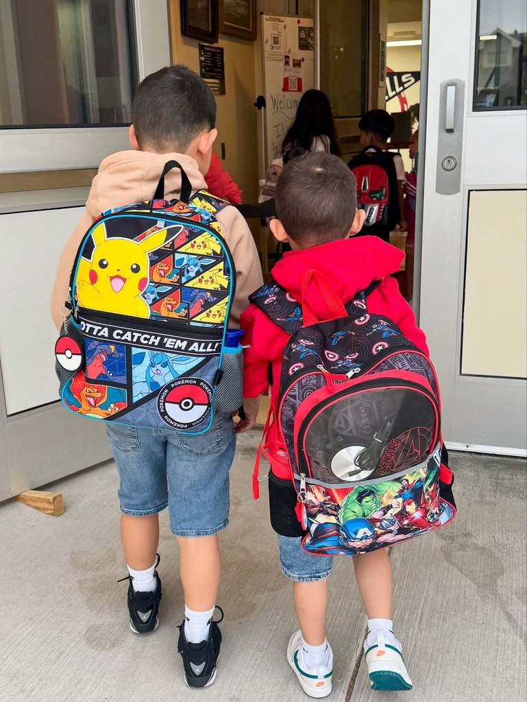 two kids walking with backpacks