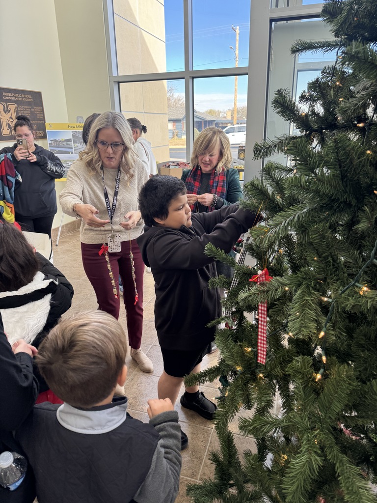 kid hanging ornament on three