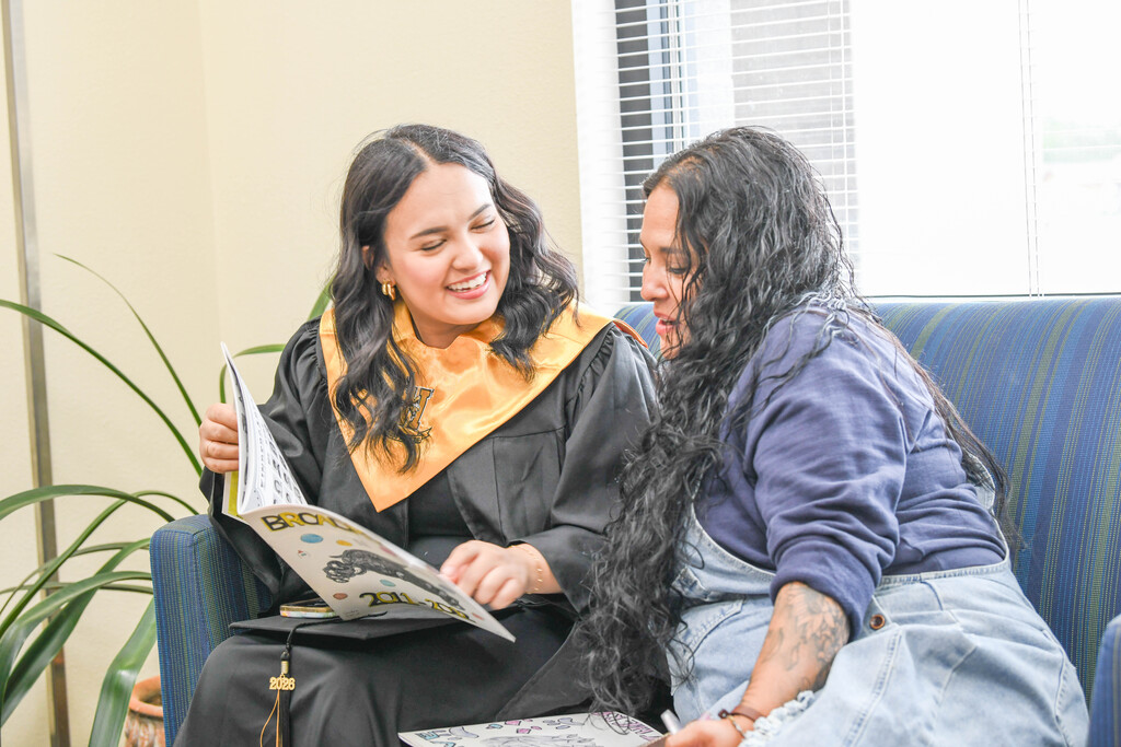 mother and daughter look at a yearbook