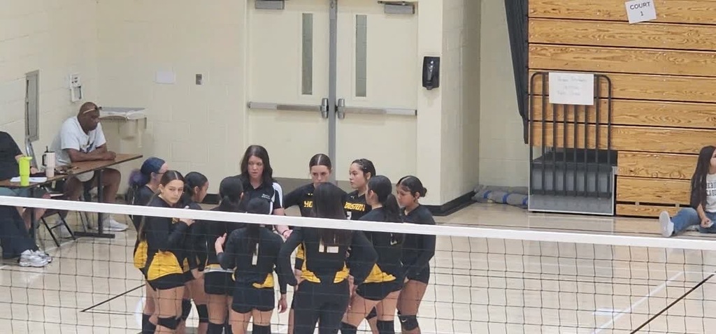 Volleyball players and coach standing in a circle