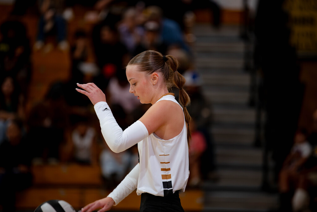 Varsity Volleyball player prepares for her serve. 