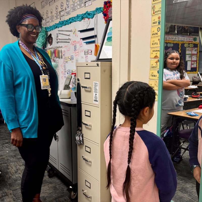teacher looking at student looking in morror