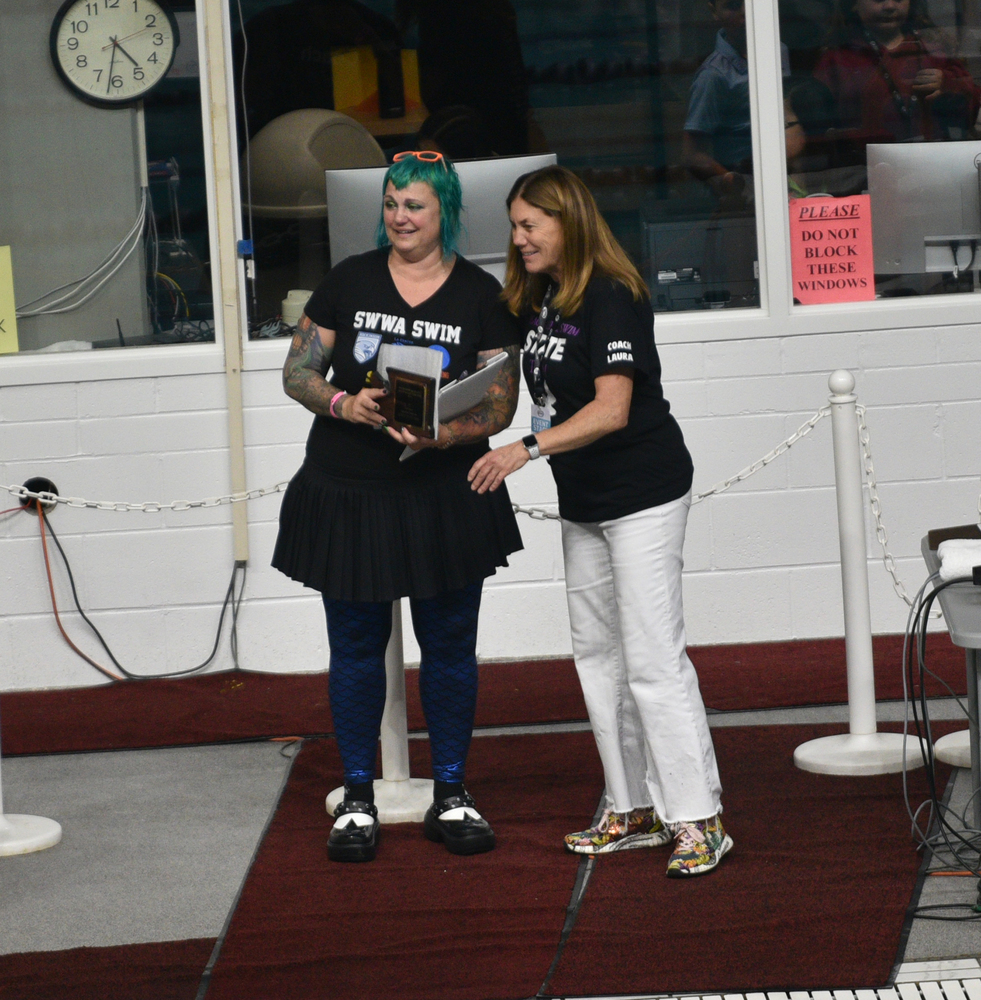 Picture and Caption from Tim Martinez, The Columbian: Michelle Jacobs-Brown (left), the coach of a seven-school co-op in Clark County, receives the 2A/1A coach of the year honor by the Washington Interscholastic Swim Coaches Association as the 2A/1A state girls swimming championships at the King County Aquatic Center in Federal Way on Saturday, Nov. 15, 2025. (Tim Martinez/The Columbian)