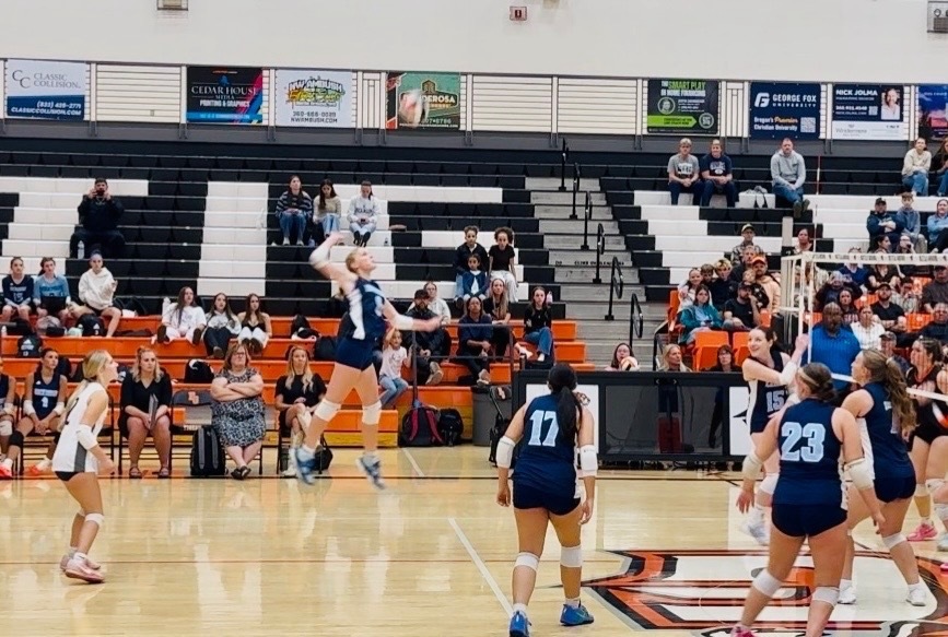 Photo of HHS Volleyball player jumping for a kill