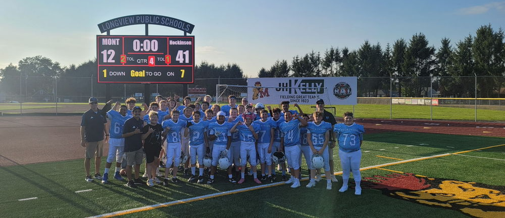 HMS Football Team in front of scoreboard that reads: Monticello 12 - Hockinson 41