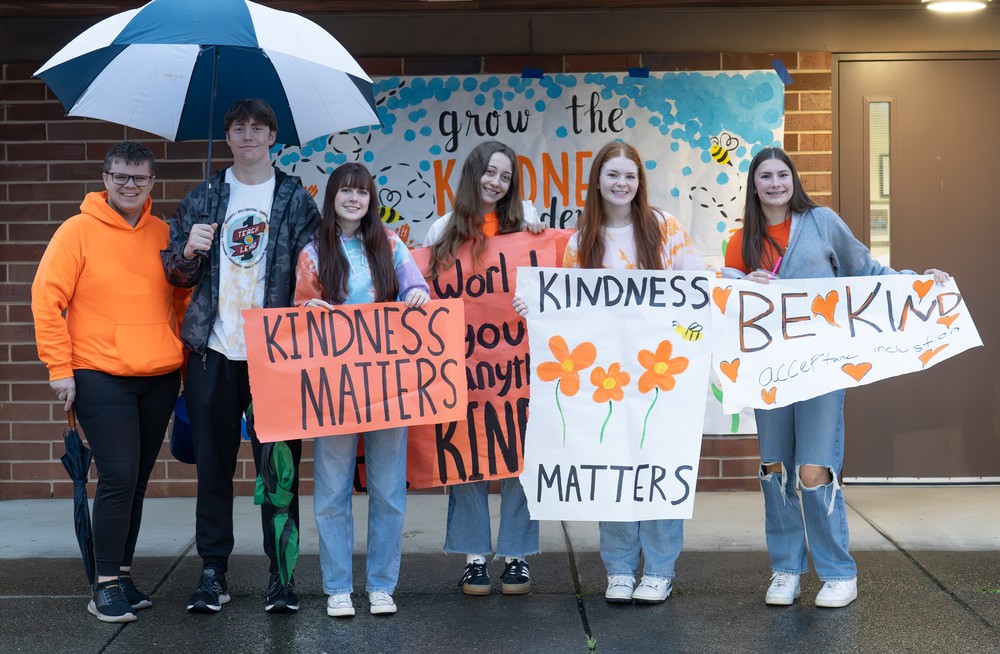 Students stand with kindness posters