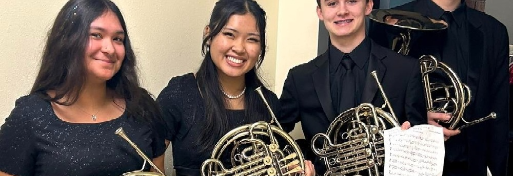 Group of students pose indoors wearing formal black attire