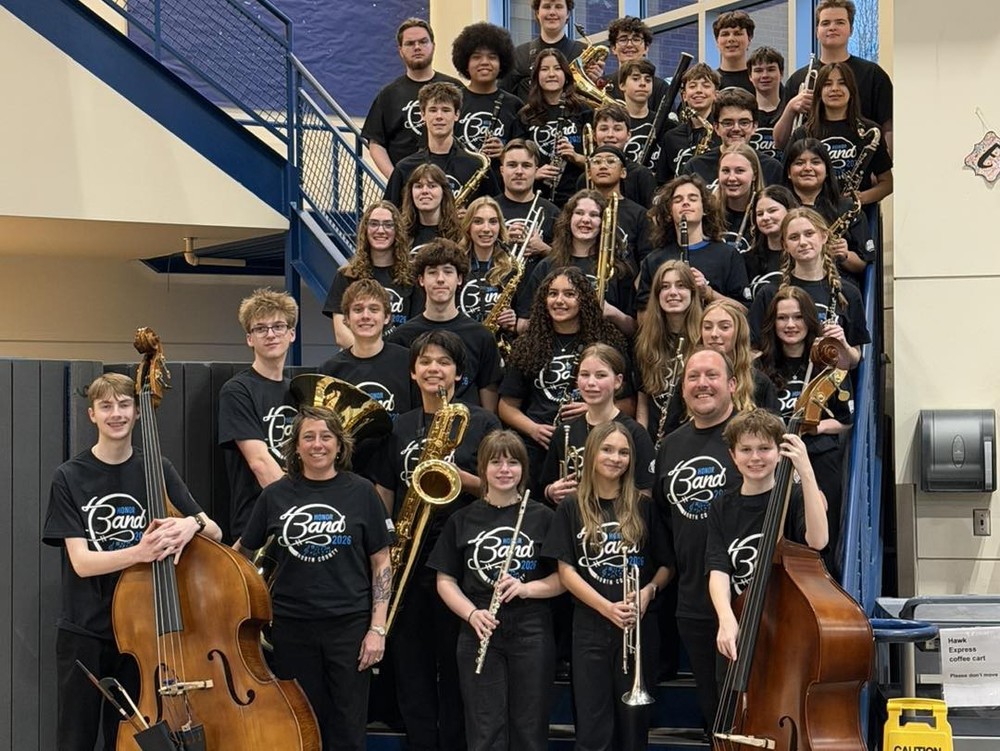 Middle and high school students pose indoors with instruments.
