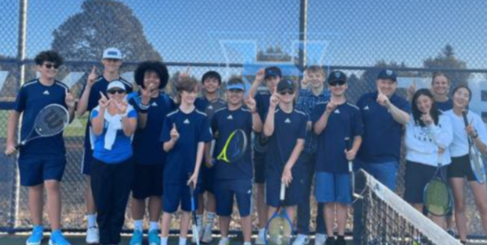 HHS Boys and Girls Tennis Teams stand together and pose for a photo.