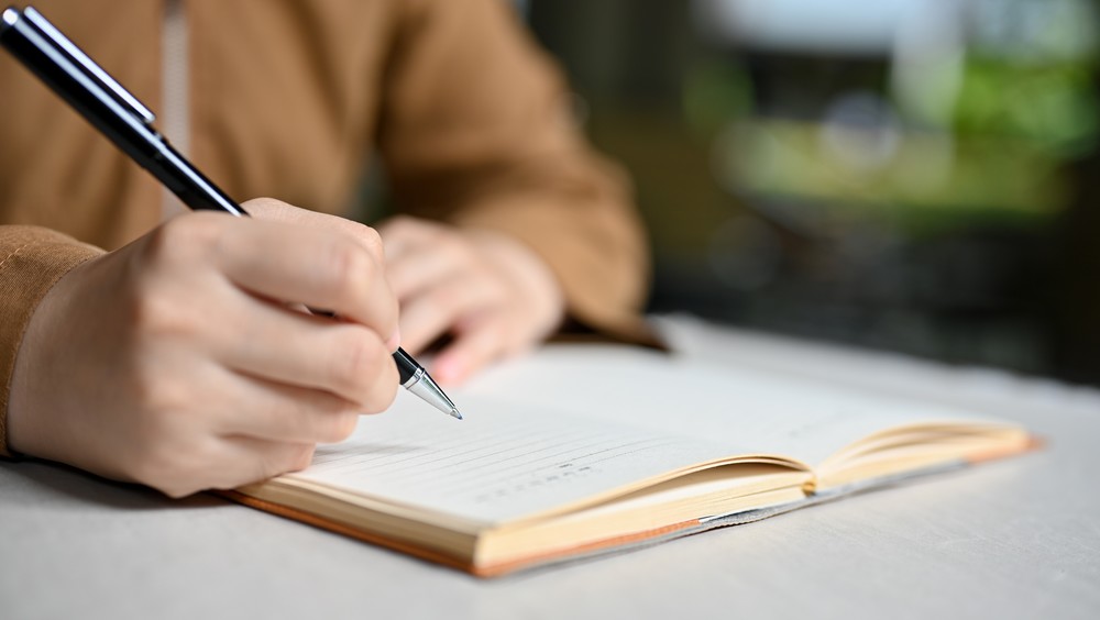 Adult writing in notebook