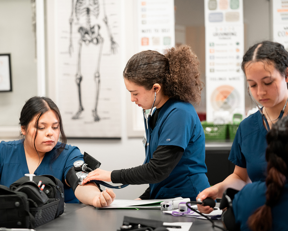 Cascadia Tech Academy's photo of three students in their medical assisting program gain hands-on experience.