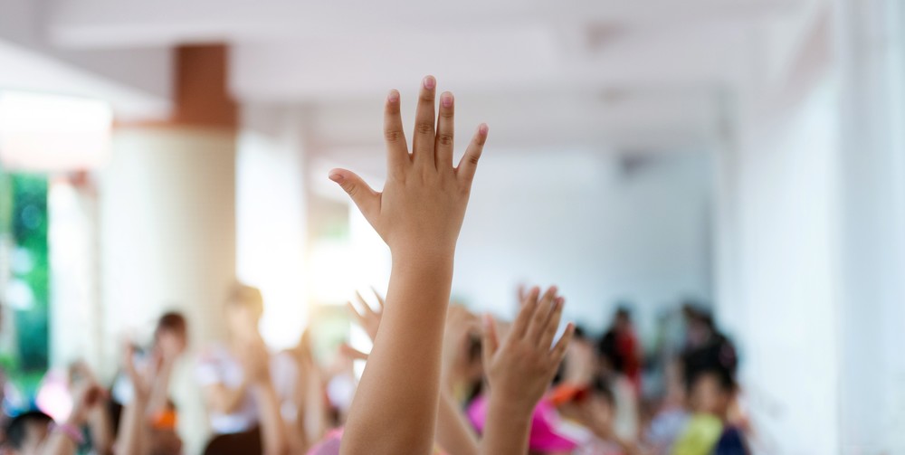 Hand raised in an indoor setting