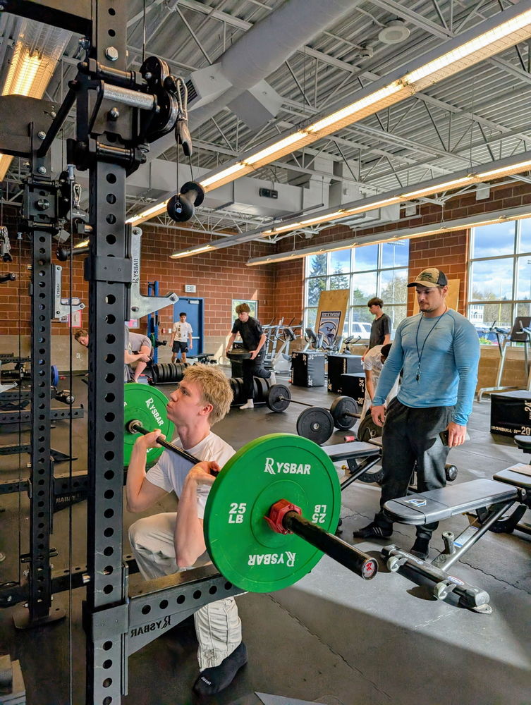A student works out under Coach Seekins' support at the HHS Strength and Conditioning Program.