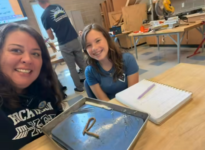 HMS Principal Colpron and student dissect a worm together in an 8th grade science class.