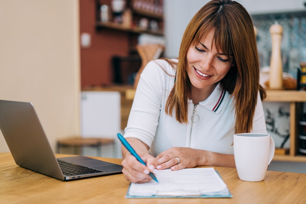 Woman fills survey with a pen and paper.