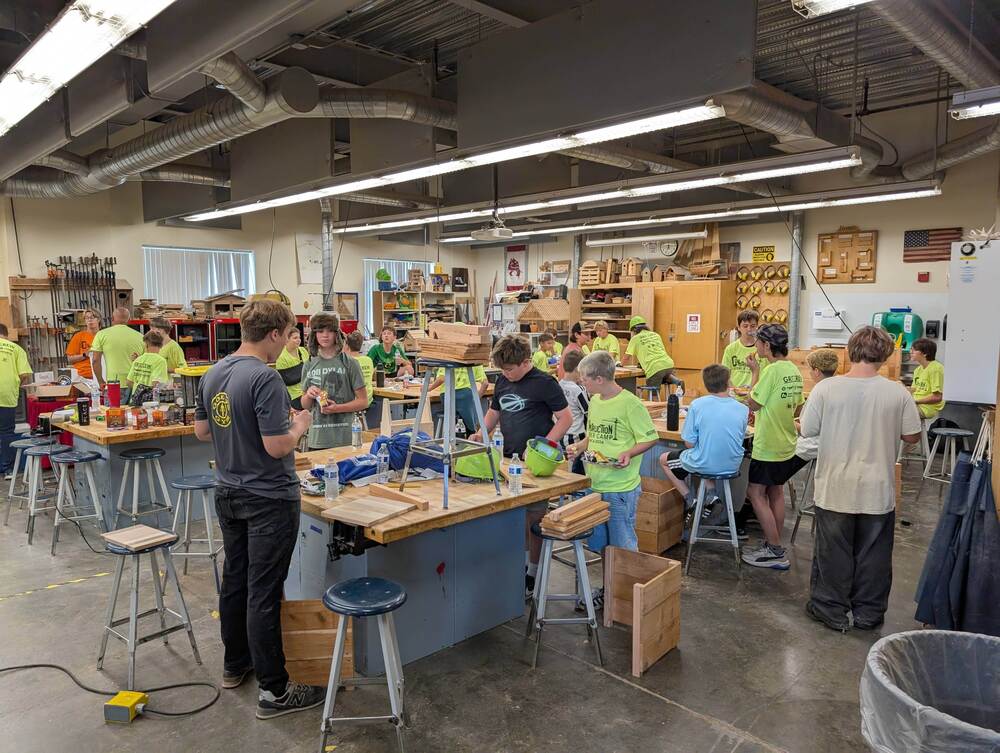 Group od students working with wood in a workshop setting.