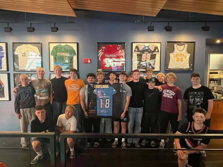 Hockinson football players hold jersey being retired at Big Al's.
