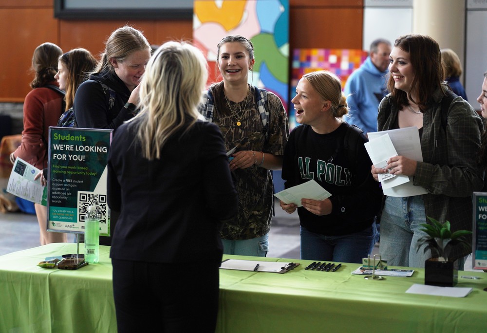 Students talk with a college representative at a Launch Fair booth at school