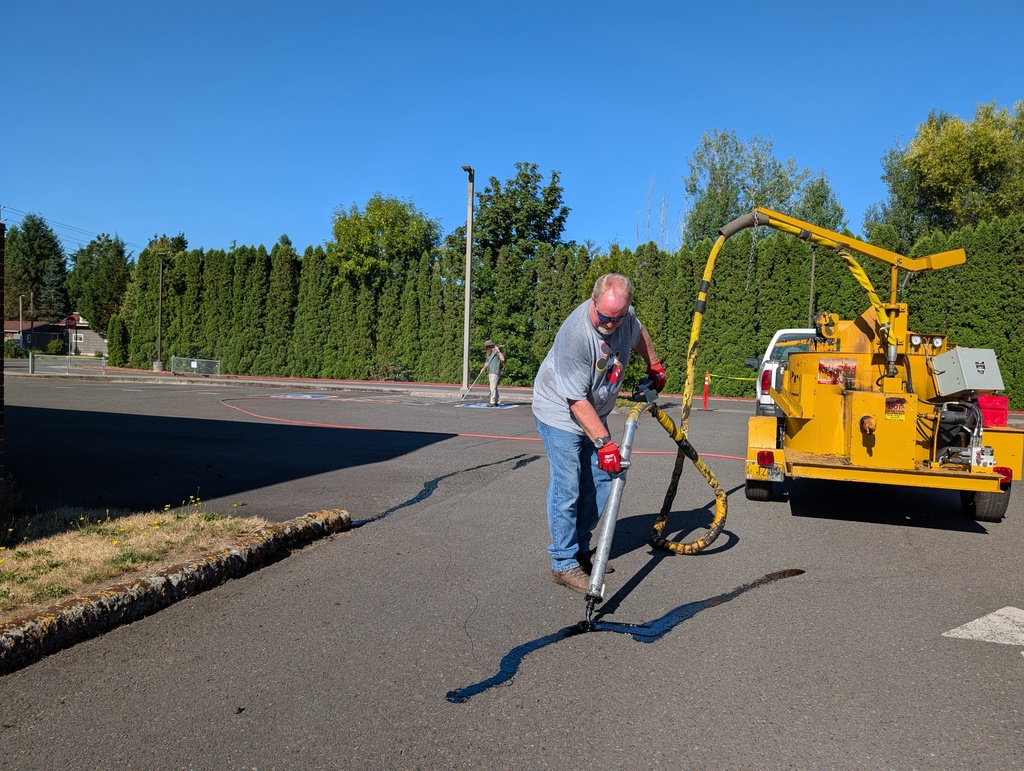 Photo of HSD Maintenance Staff sealing asphalt cracks