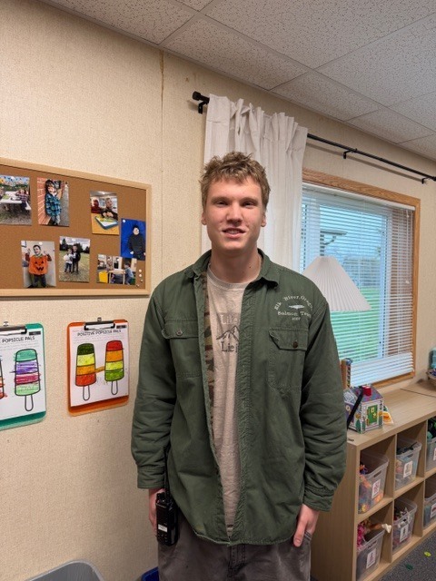 Man poses for photo in classroom