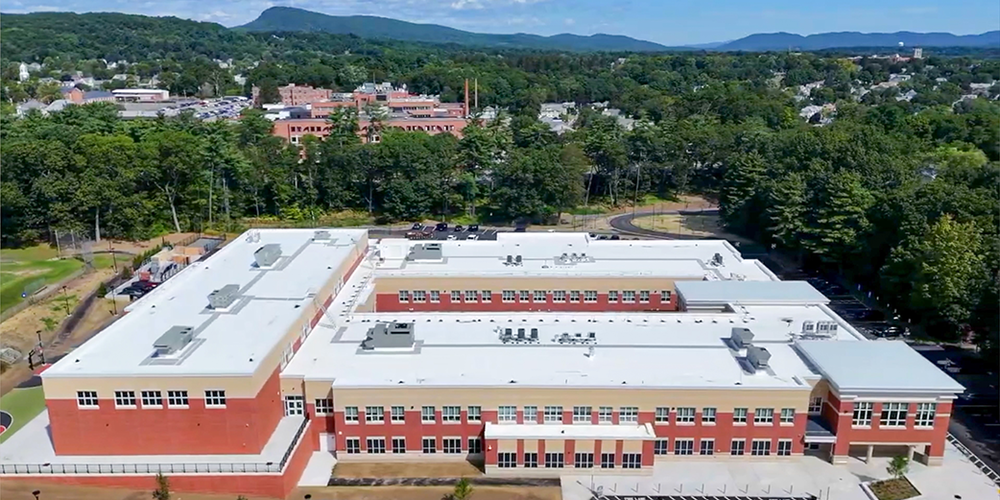 Exterior aerial view of new Peck Middle School with mountains n the background