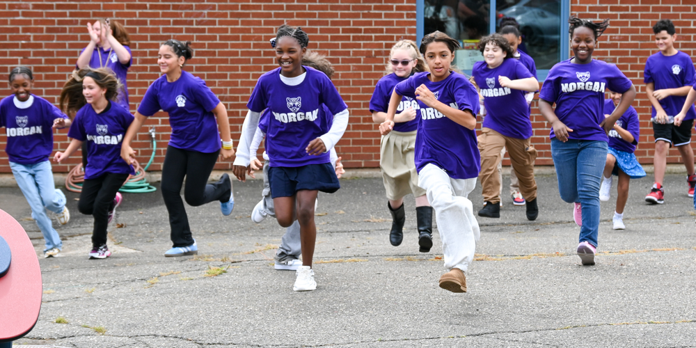 group of students running towards new playground at school