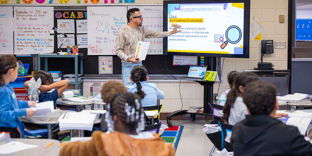 Teacher at large monitor showing lesson in Spanish to students