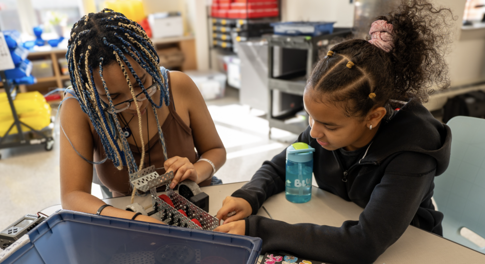 Two students work on a robotics project