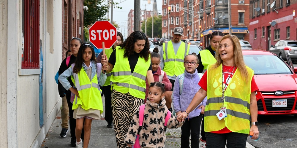 A group of students and adults walk to school