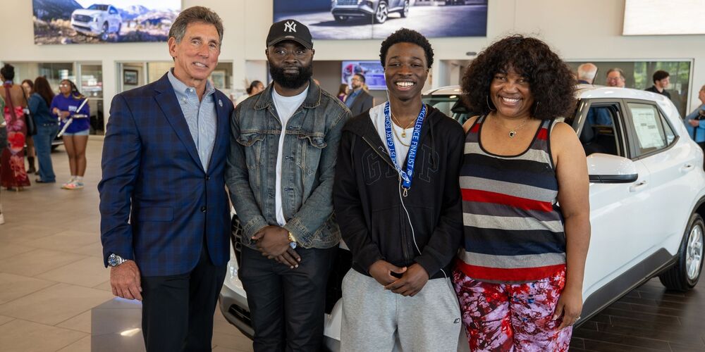 group of 4 people standing in front of car that was apart of a giveaway