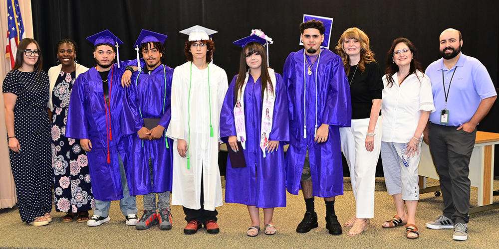 Graduating seniors pose with school administrators and staff