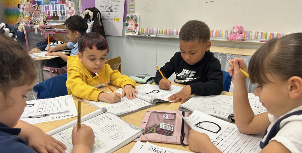 Students work on handwriting in Spanish-language workbooks