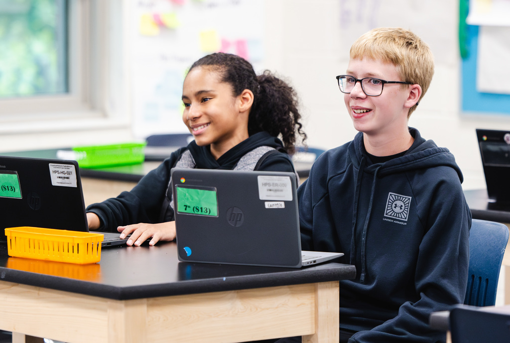 Two students at Sullivan School smile during a lesson
