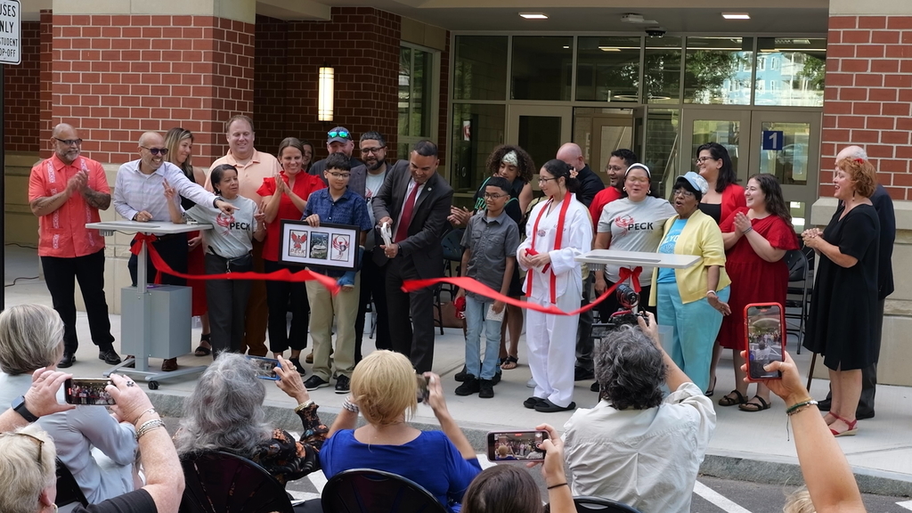 Mayor Garcia cuts ribbon as people cheer