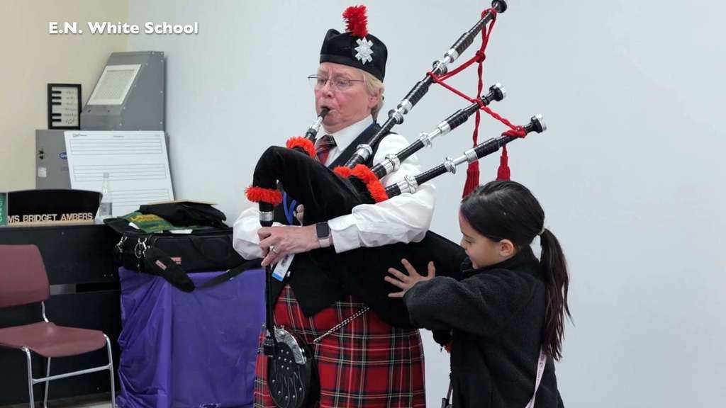 Student helps with bagpipe demonstration  during music class at  E.N. White School