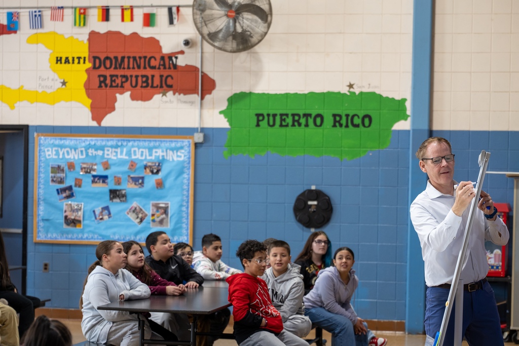 Dan speaking to students and writing on white board