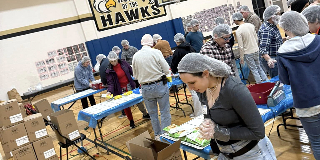 People wearing hairnets and packing food supplies