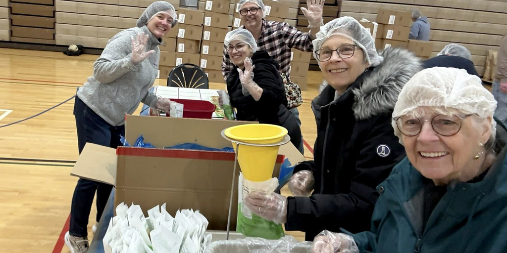 People wearing hairnets and packing food supplies