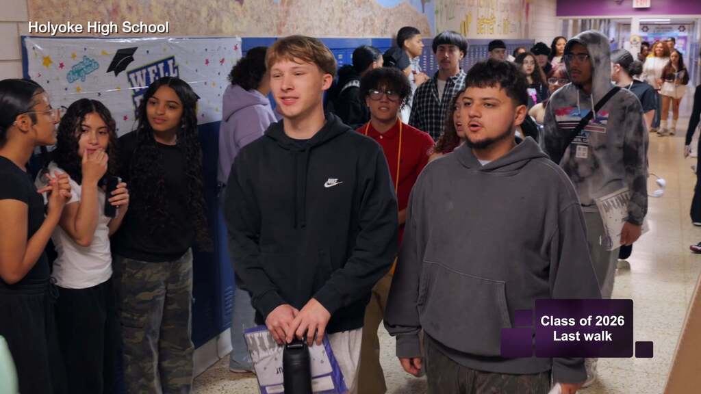 Seniors walk down the hall of Holyoke High School for the last time as people come out of their classrooms to cheer them on.