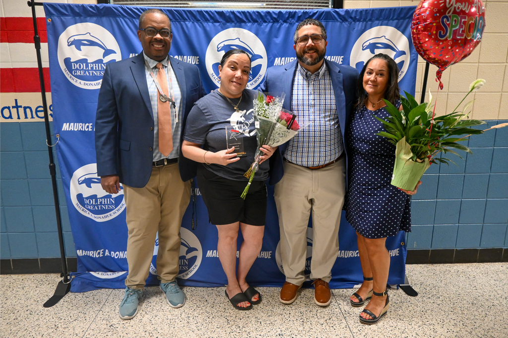 group of people standing in front of blue backdrop