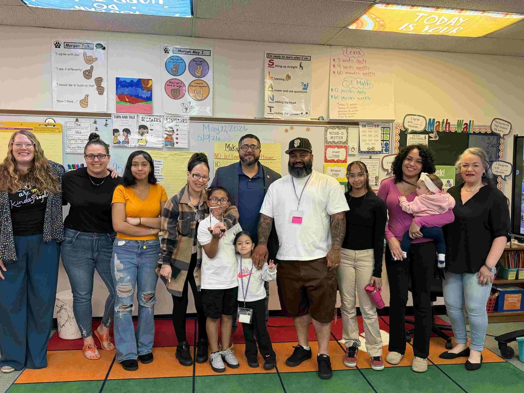 group of people standing in front of whiteboard in classroom.