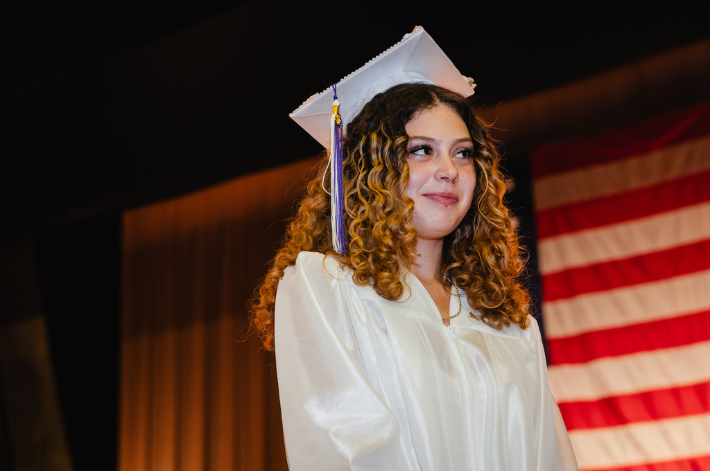 Graduate smiling as her teacher talks about her