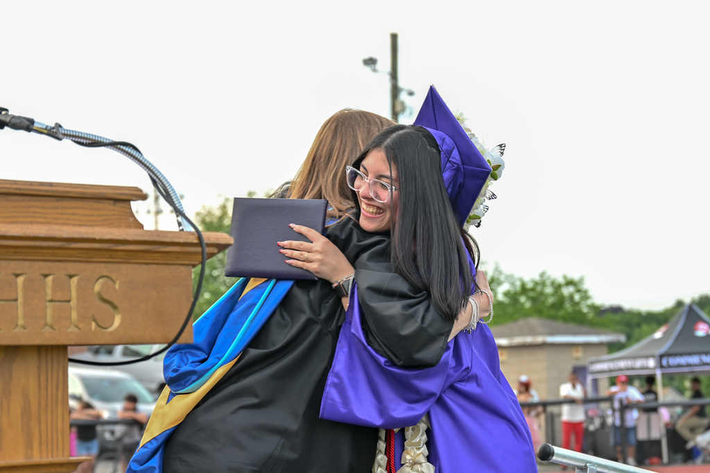 Graduate hugs her principle when she receives her diploma