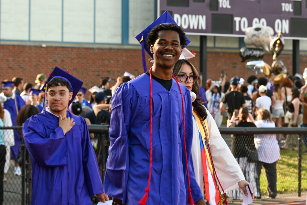 Graduate smiles while entering the field