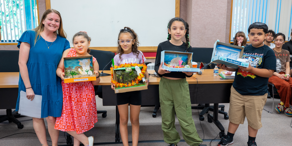 group of students standing holding school projects