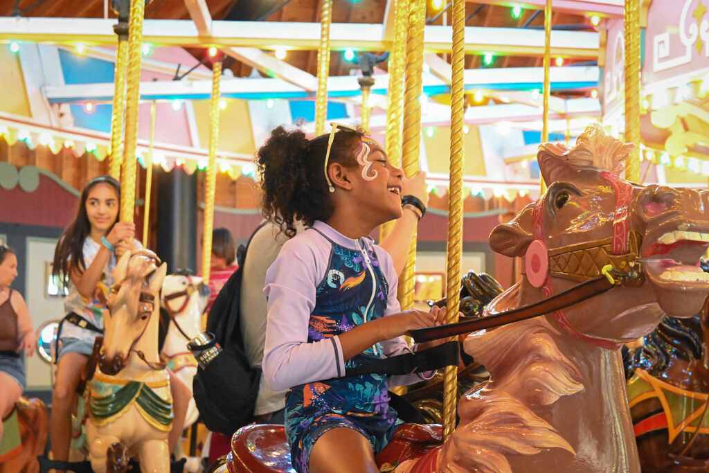 child smiling riding merry-go-round