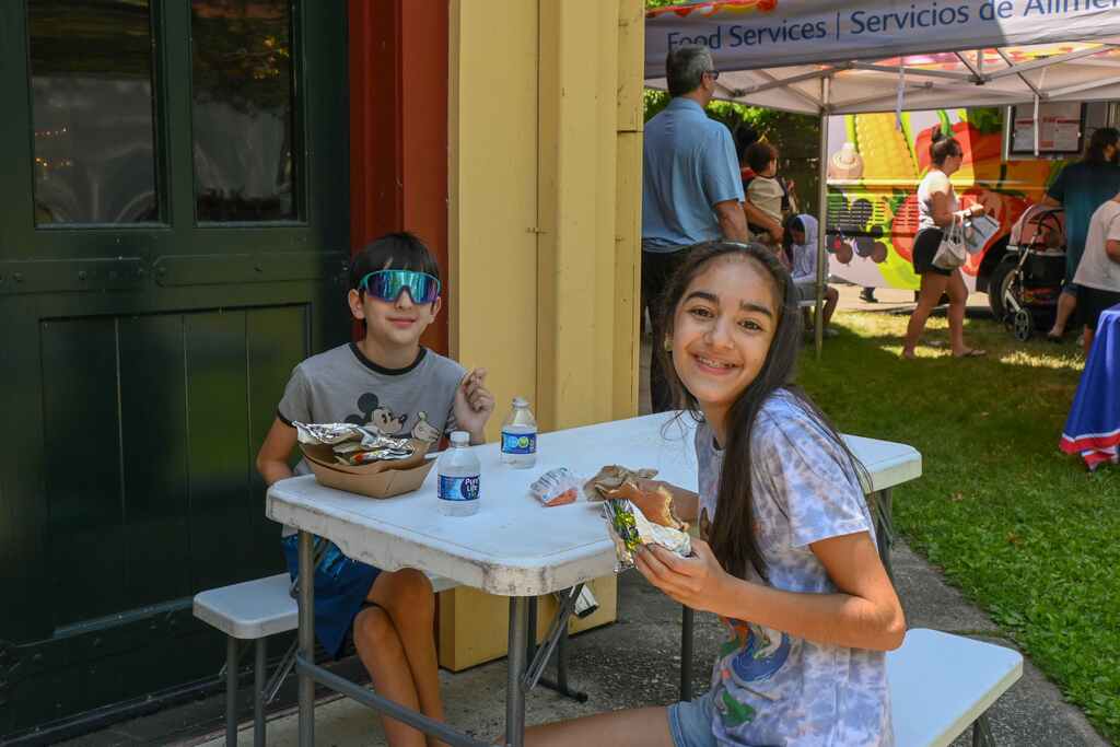 two children sitting at table eating lunch