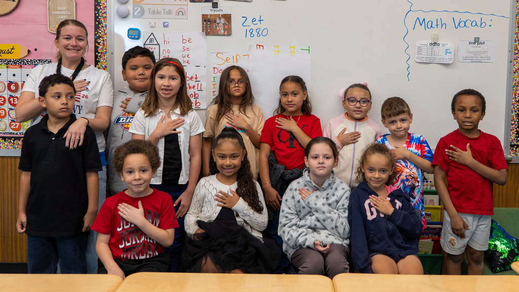 group of students standing posing with their hand over their heart for the 9/11 25th anniversary